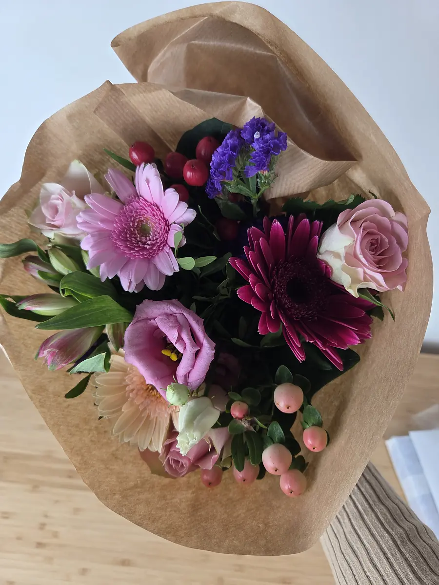 blumenshop.de Ersatzstrauß am Liefertag im Papier, rund gebunden mit rosa, apricotfarbener und dunkelpinker Gerbera, Rosen, Lisianthus und Johanniskraut