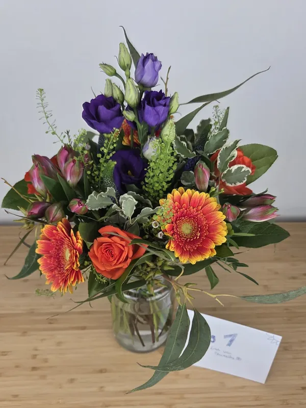 Bluvesa Strauß Happy Birthday aus unserem Testkauf am Liefertag mit zweifarbigen Gerbera, Rosen, lila Lisianthus und Alstromerien in der Knospe