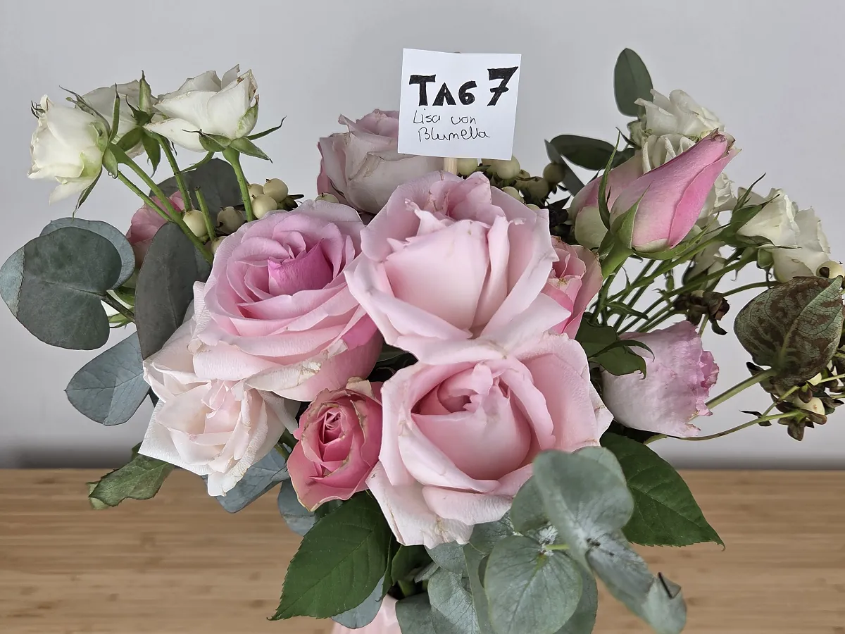 Nahaufnahme des Bloom & Wild Straußes an Tag 7, Rosen offen, rechts dunkle Hypericum-Beeren und fleckige Blätter